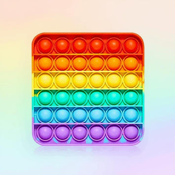  Lachend kind speelt met een regenboogkleurige pop-it, een populair zintuiglijk fidget speelgoed.